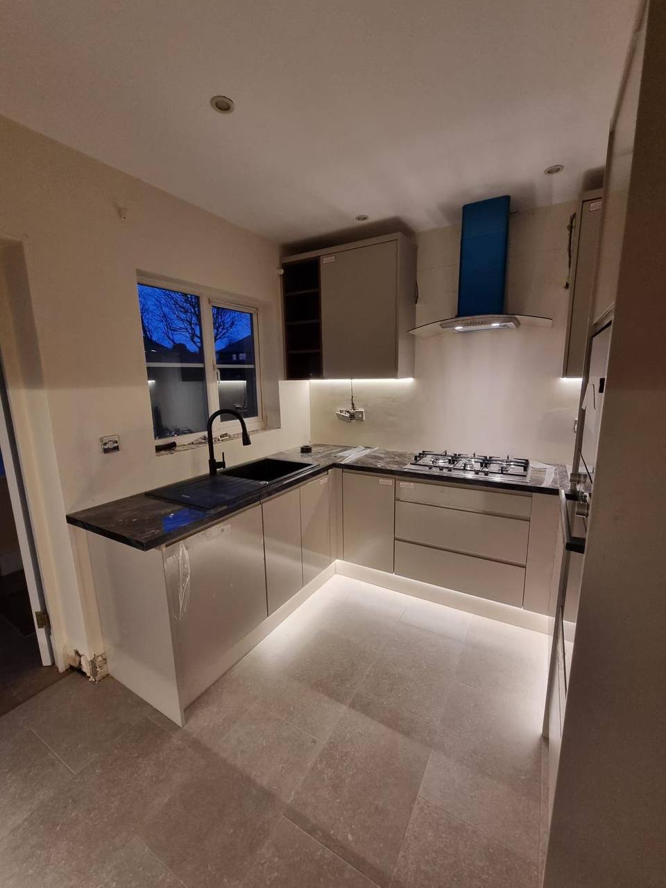 Modern handleless kitchen with marble-effect worktop, gloss cabinetry and under-cabinet lighting