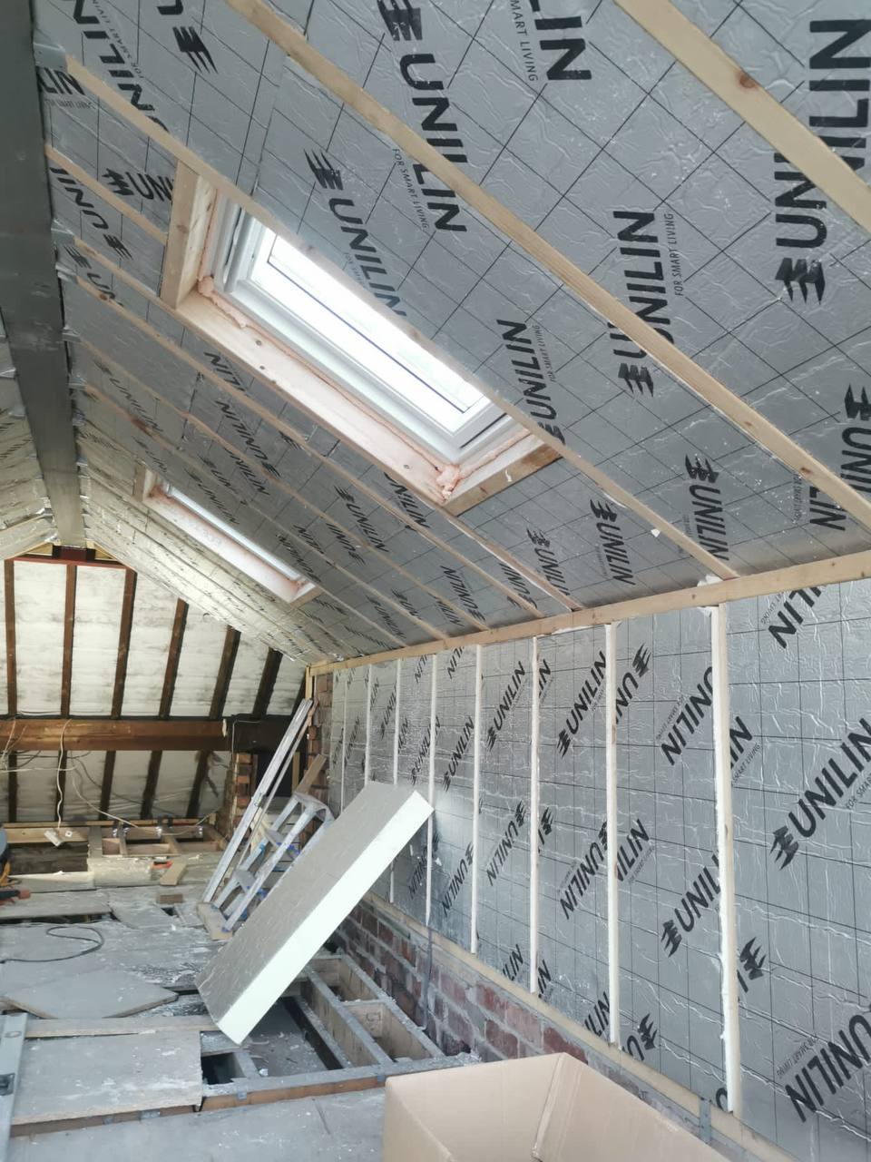 Loft conversion in progress with insulated roof boards and new Velux roof windows